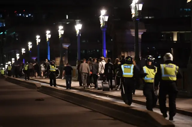 People are lead to safety on Southwark Bridge away from London Bridge