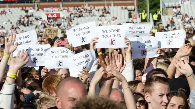 Music fans stand together at One Love Manchester