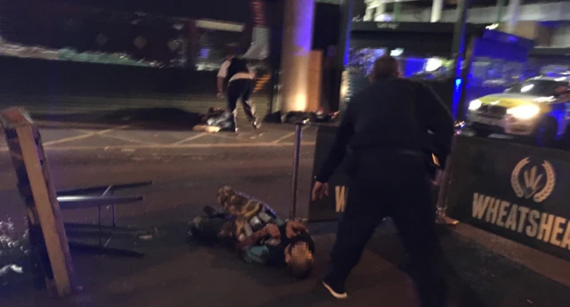 A man on the ground with what looked like canisters strapped to his body