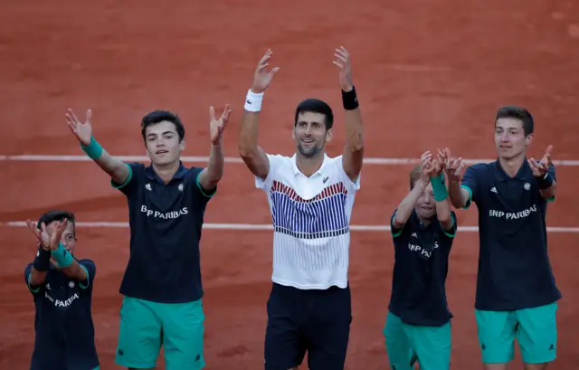 Novak Djokovic with ball boys and girls