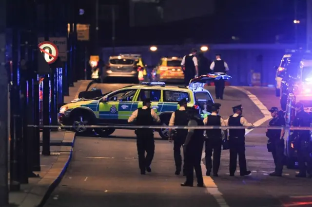 Police officers walk at the scene of the attack