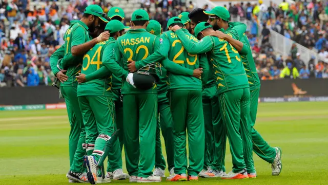 Pakistan huddle on the outfield prior to the resumption of play