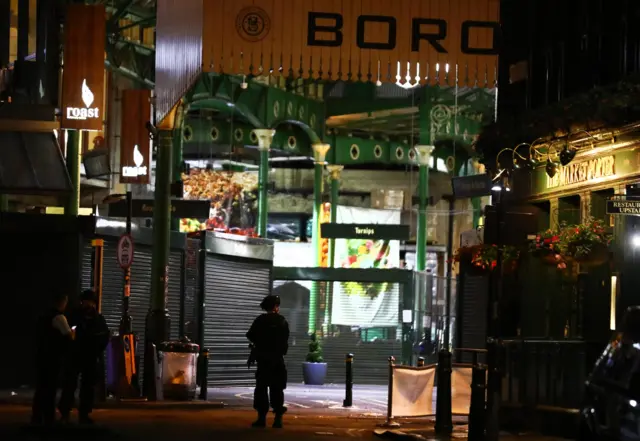 Armed police officers stand in Borough Market after an incident in the London Bridge area of London