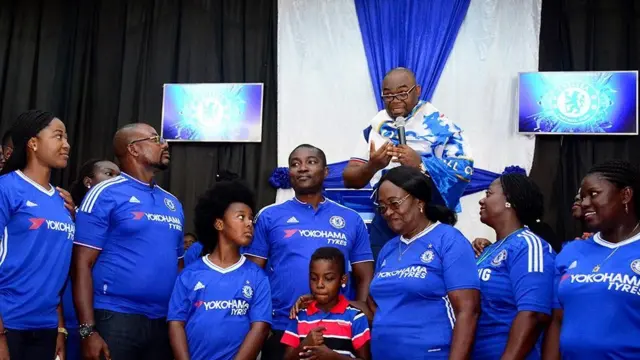 People in church wearing Chelsea shirts
