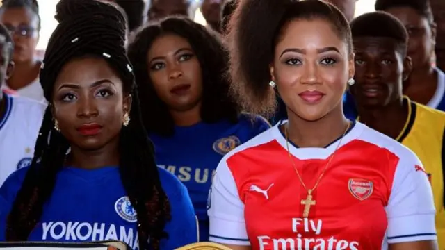 Two people wearing an Arsenal and Chelsea shirt