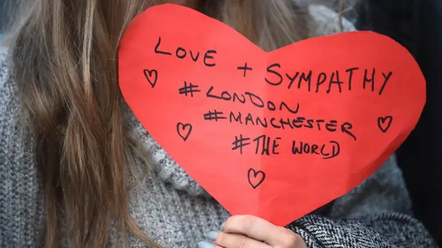 Woman holds a message for Londoners from Manchester