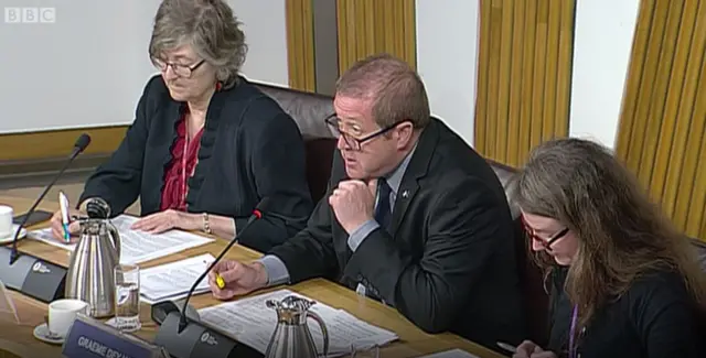Committee convener Graeme Dey reminds everyone that there will be minute's silence at 11am