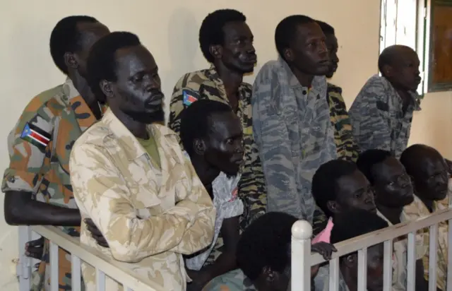 South Sudanese soldiers suspected of raping foreign aid workers and killing a local journalist stand before appearing in a military court in South Sudan"s capital Juba