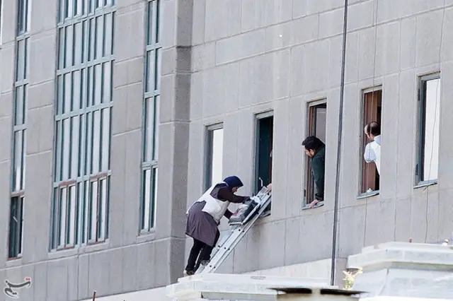 A woman is evacuated during an attack on the Iranian parliament in central Tehran, Iran, 7 June 2017