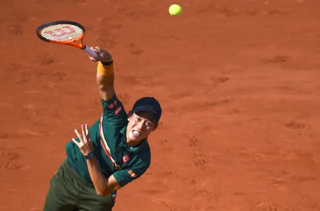 Kei Nishikori serves