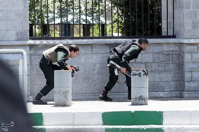 Members of Iranian forces take cover during an attack on the Iranian parliament in central Tehran, Iran, 7 June 2017.