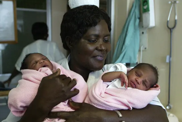 Christine Namutebi, a maternity matron at Nairobi's Avenue Park Hospital, holds two baby girls