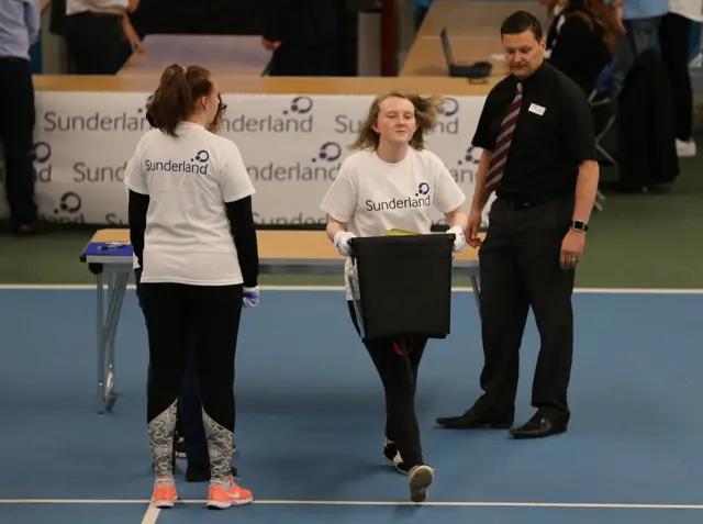 Young woman running with ballot box