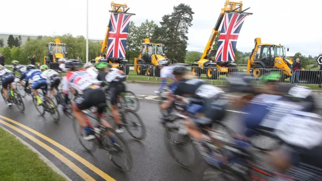 Riders going past JCB diggers in Rocester