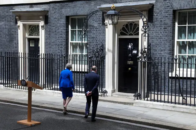 Theresa May and her husband Philip May walk into 10 Downing Street