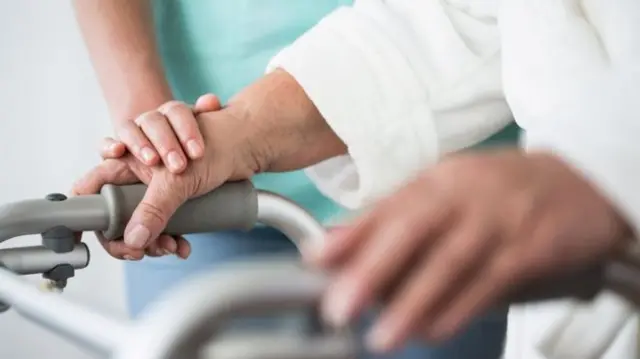 Patient with hands on walking frame