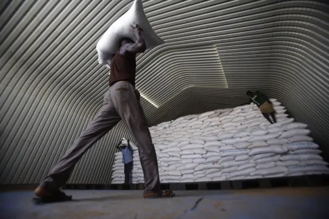 World Food Program (WFP) workers stack humanitarian aid parcels that will be distributed to South Sudanese refugees, on May 20, 2017, at Al-Obeid airport in Sudan"s North Kordofan state.