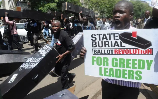 Kenyan civil activists carry coffins as they take to the streets in Nairobi, on January 16, 2013, during a 'State Burial' for the members of Kenyan parliament proposal to award themselves millions of shillings in a selfish send-off deal that included state funerals.