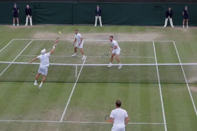 Finland"s Henri Kontinen (R bottom) stands by as his partner Australia's John Peers volleys at the net against opponents US player Ryan Harrison and New Zealand's Michael Venus during their men"s doubles quarter-final match on the eighth day of the 2017 Wimbledon Championships