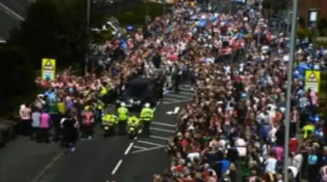 Crowds surround the hearse