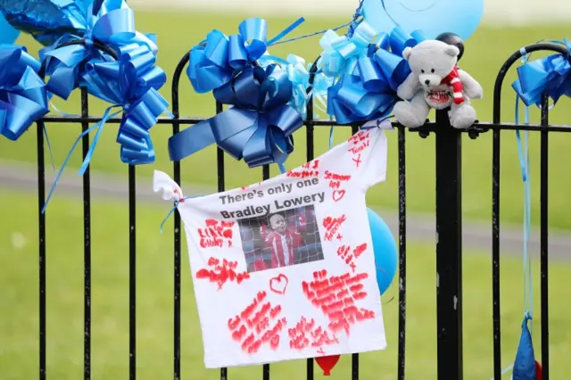 Pictures and decorations hung on a gate