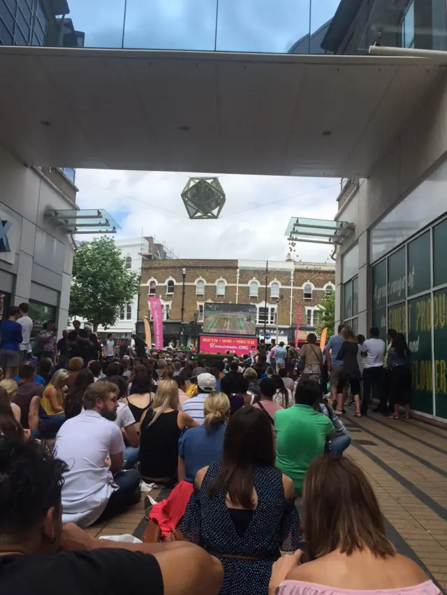 Fans watch on a big screen in Wimbledon tow centre