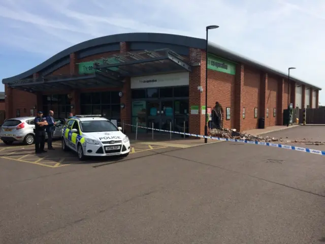 Police vehicles and officers at the supermarket