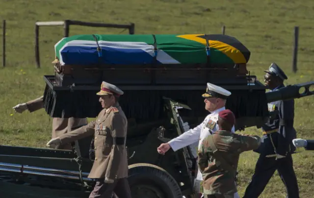 The funeral procession carrying the coffin of South African President Nelson Mandela moves inside his compound for the funeral ceremony in Qunu on December 15, 2013.