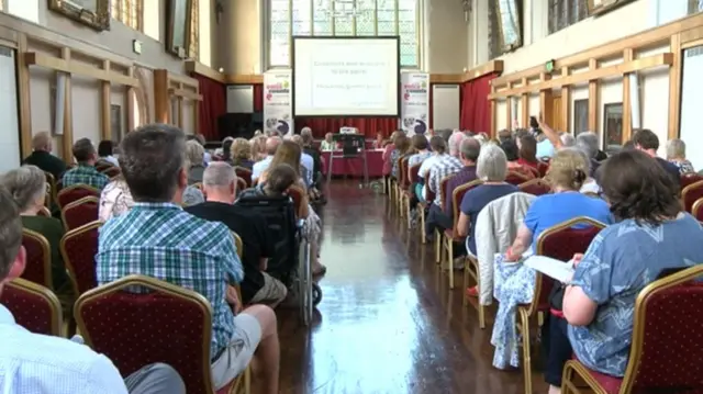 Seated audience at meeting in Blackfriars Hall