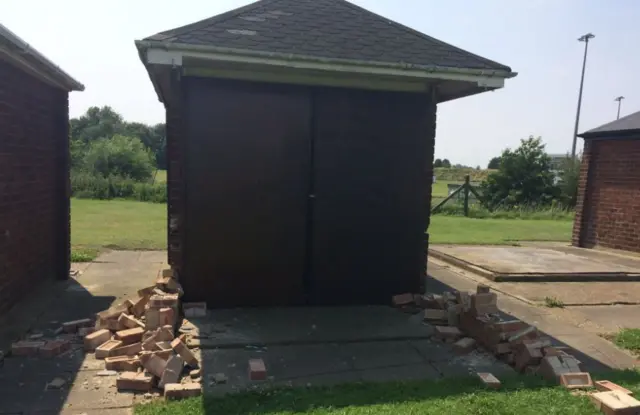 Beach hut with broken bricks all around it