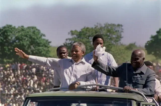 Nelson Mandela (L) and Zambian president Kenneth Kaunda (R) wave to the crowd as they arrive at a mass rally of ANC, at Independent Stadium, 03 March 1990 in Lusaka, seat of the exiled ANC