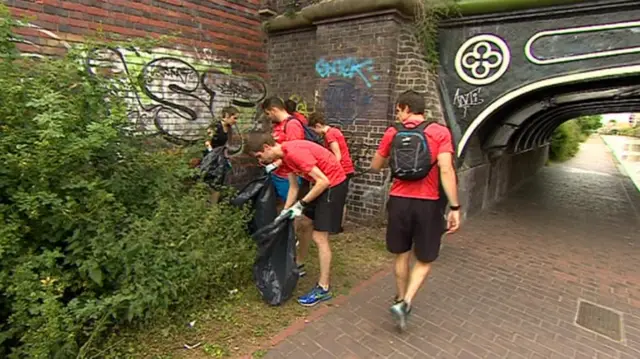 Running group picking up litter alongside a canal in Birmingham