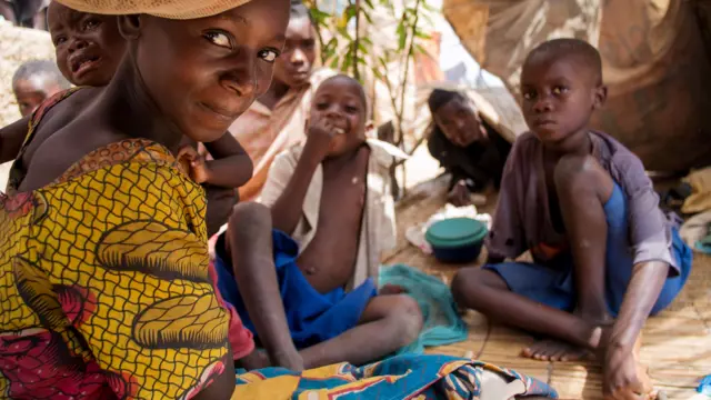 Burundian refugees gather along the shoreline of the Tanganyika lake in the fishing village of Kagunga, in May 2015. At the time, UNHCR was transporting approximately 2,000 refugees per day to a transit camp at the stadium in Kigoma.