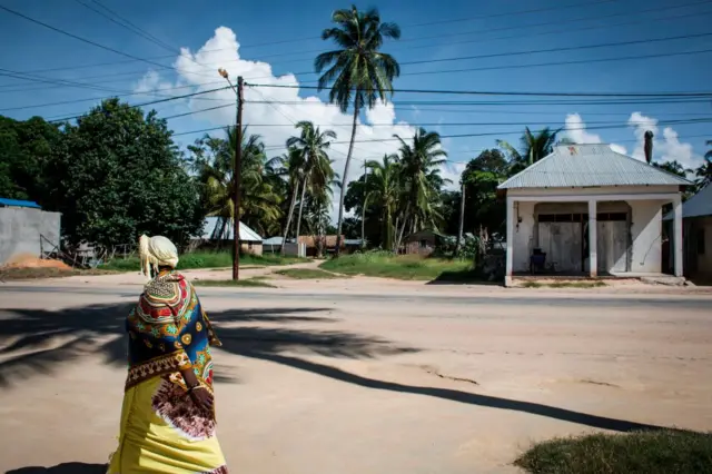 A Mozambican woman walks in Palma, on February 16, 2017. The small, palm-fringed fishing town of Palma was meant to become a symbol of Mozambique's glittering future, transformed by one of the world's largest liquefied natural gas projects, but it is now under threat from construction delays, fallen gas prices and a huge government debt scandal