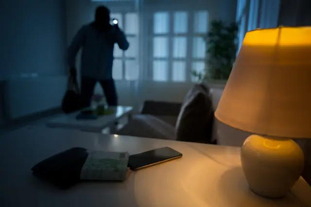 File image of a burglar in a house