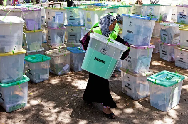 Woman carrying ballot boxes