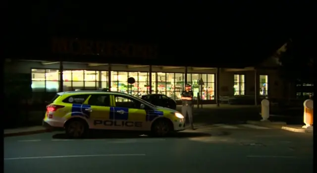 Night time shot showing police vehicle outside Morrisons supermarket