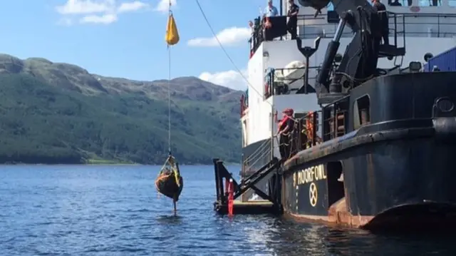 Bomb being winched aboard ship