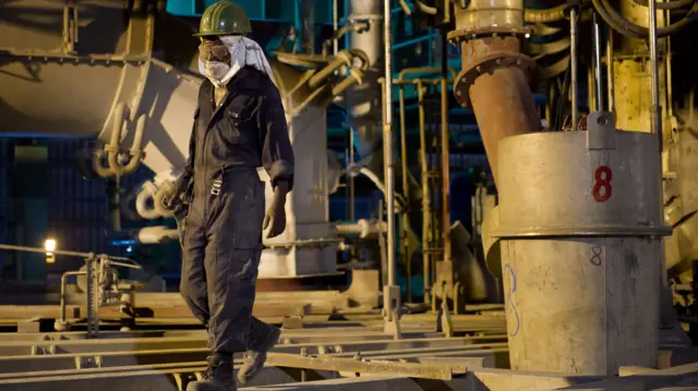 A Congolese worker walks through a mineral processing plant