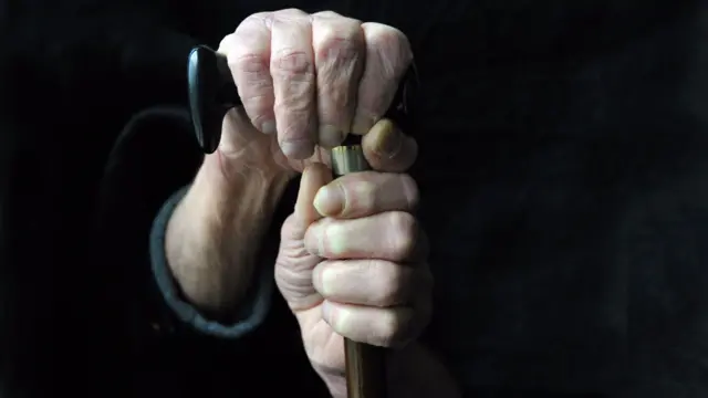 Hands holding stick by dementia patient