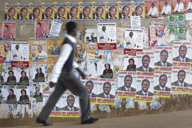 Man walking past election posters