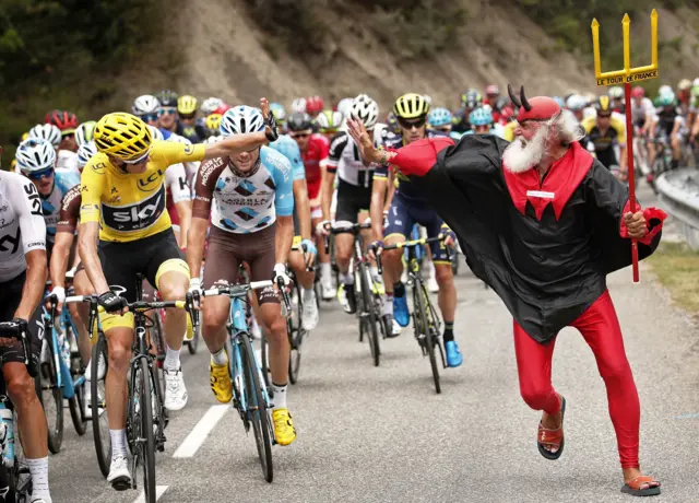 Chris Froome holds out his hand to the Tour Devil