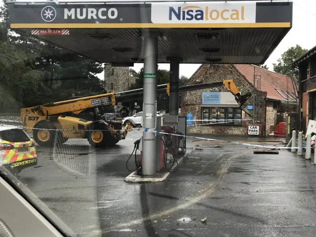 Forklift on forecourt, with police vehicles and police tape