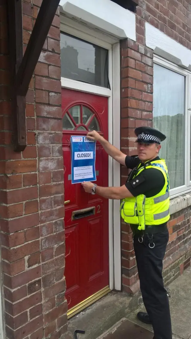 Police stick closure notice on door of house