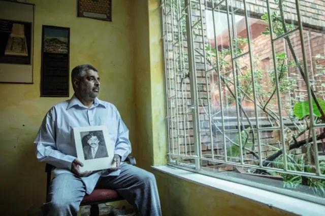 Imtiaz Cajee, the nephew of Ahmed Timol, an anti-apartheid activist brutally murdered in police custody in October 1971, holds a portrait of his uncle at his house on May 25, 2017 in Pretoria.