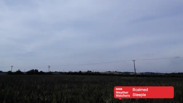 Cloudy skies over a field in Steeple.