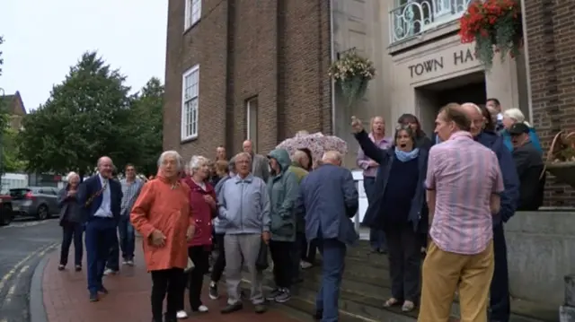 People protesting outside a town hall