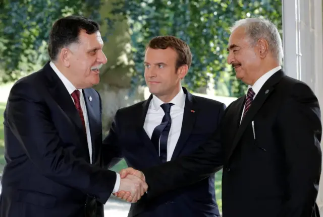 Haftar shaking the hand of a rival