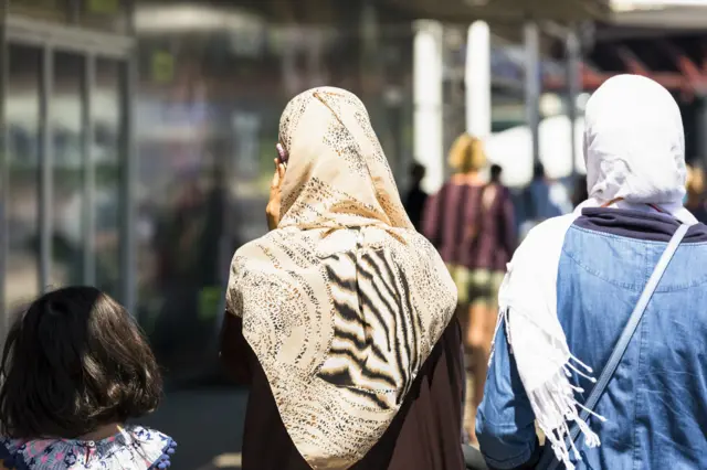 Rear view of two muslim women with child