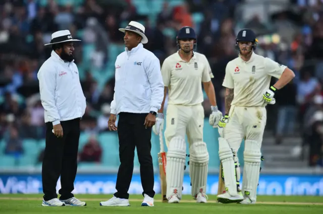 Alastair Cook and Ben Stokes wait as the umpires discuss the rain